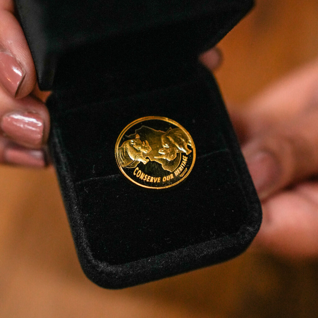 Gold African medallion presented in a black display case